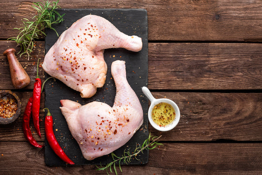 Seasoned chicken legs on cutting board